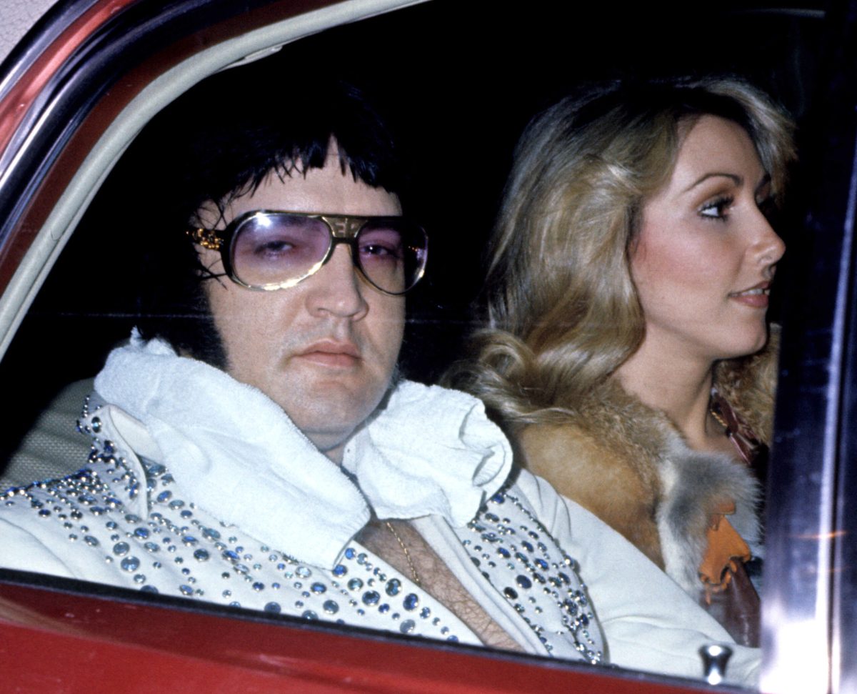 Elvis Presley rides in car. 