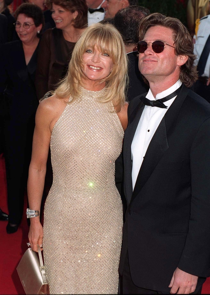 Goldie Hawn and Kurt Russell pose on red carpet. 